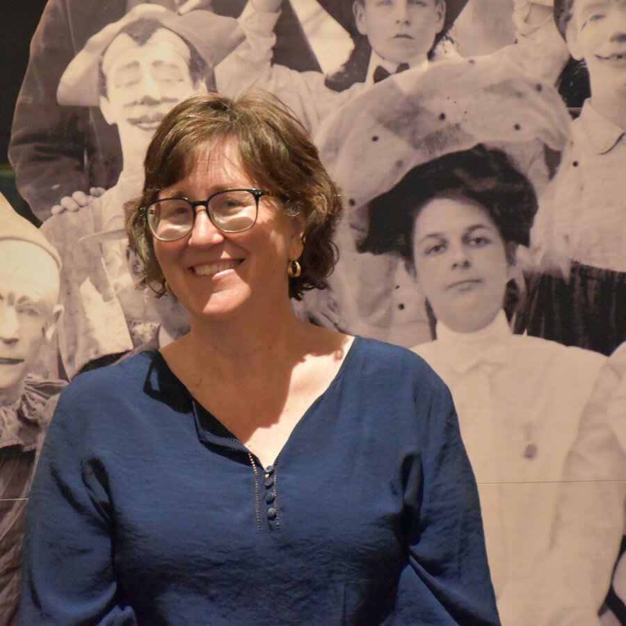 Lynne Klippel standing among historical circus photographs